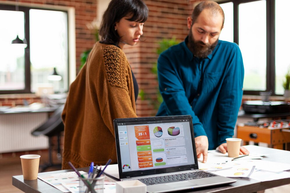 Two people reviewing SEO performance data on a laptop